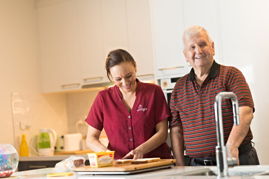An Envigor carer helps a client in the kitchen to prepare food