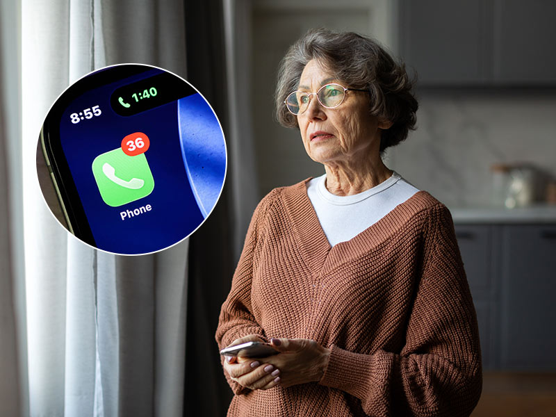 An older woman holding her phone is concerned about her home care provider. They have not been picking up her phone calls.